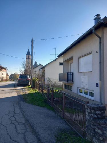 a car parked next to a building with a fence at Shalom Krašić in Krašić