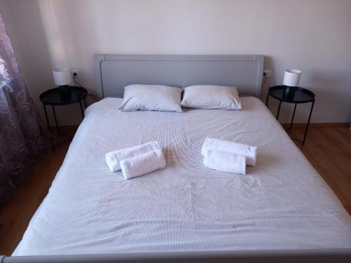a white bed with two white towels on it at Shalom Krašić in Krašić