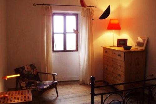 a living room with a window and a dresser and a chair at Vintage House Daška in Grožnjan