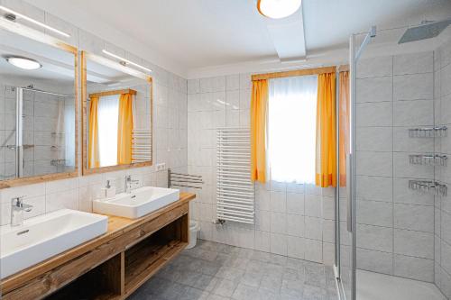 a bathroom with two sinks and a shower at Haus Isabella Obertauern in Obertauern