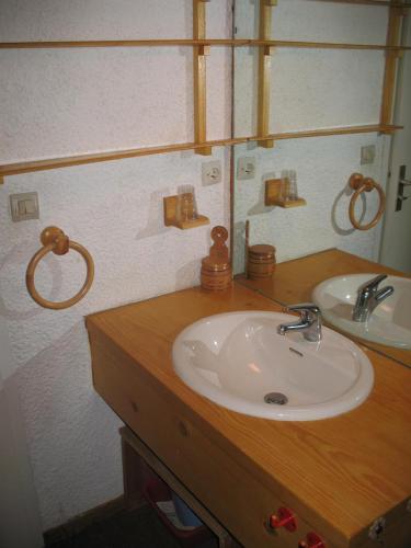 Val Thorens Studio Cabine 4 Personnes في فال تورن: منضدة الحمام مع الحوض والمرآة