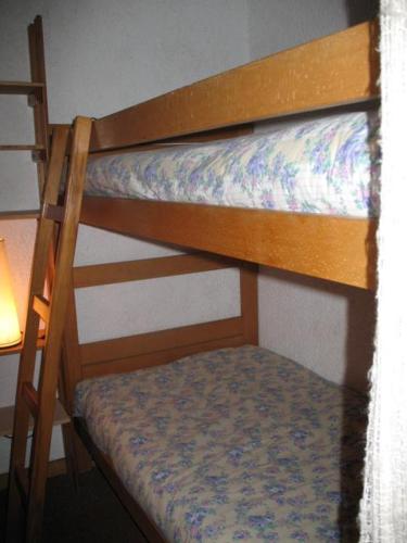 Val Thorens Studio Cabine 4 Personnes في فال تورن: سرير بطابقين في غرفة مع مصباح
