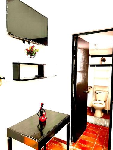 a living room with a table and a toilet at Titos Centric Home in Morelia