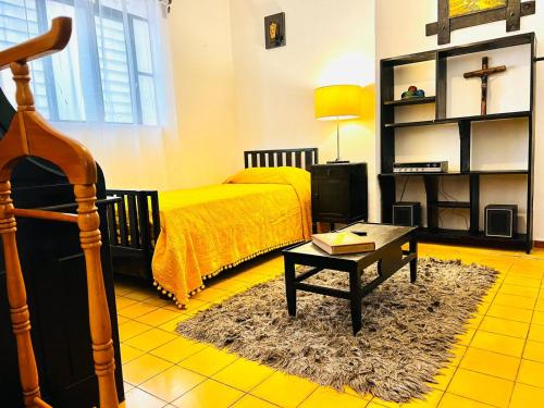 - une chambre avec un lit, une table basse et une table dans l'établissement Titos Centric Home, à Morelia