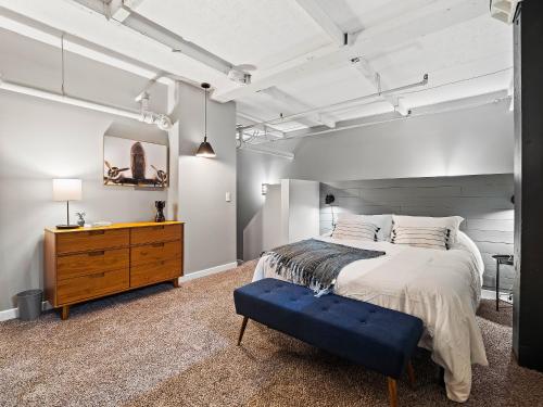 a bedroom with a bed and a wooden dresser at Lakefront Loft - Downtown - Shuffle Board Table in Cleveland