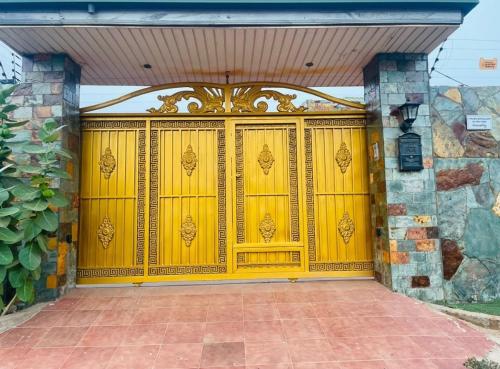 uma porta amarela de garagem numa casa com uma parede de pedra em 7 Palms Bungalow em Acra
