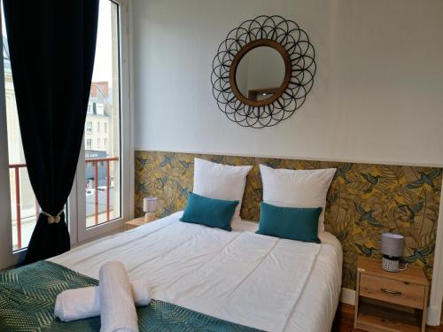 um quarto com uma cama com um espelho e uma janela em Le Refuge des bords de Loire em Blois