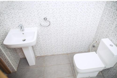uma casa de banho com um lavatório e um WC em 7 Palms Bungalow em Acra