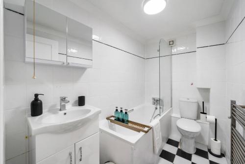 a white bathroom with a sink and a toilet at Modern 2 BR near Arsenal Stadium in London