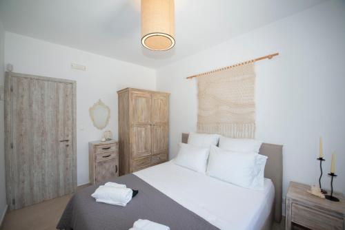 a bedroom with a bed with white sheets and white pillows at Cocos Villa in Super Paradise Beach