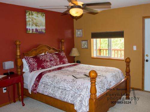 a bedroom with a bed and a ceiling fan at A Hyde Away Inn B&B in Tok