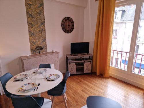 uma sala de jantar com uma mesa e cadeiras e uma televisão em Le Refuge des bords de Loire em Blois