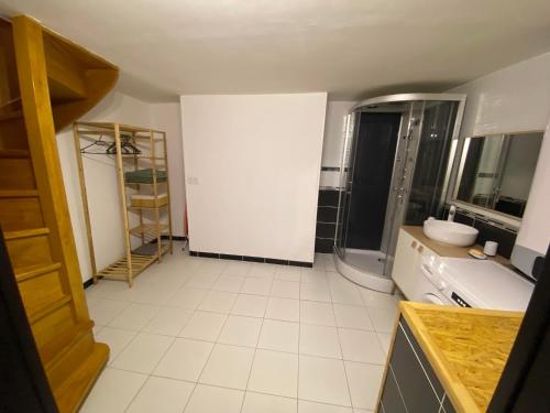 a bathroom with a white tiled floor and a white wall at Bienvenue chez Coco in Dunkerque