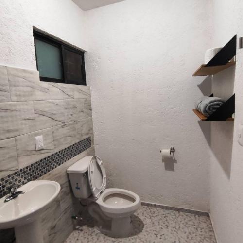 a bathroom with a toilet and a sink at Bonito departamento in Morelia
