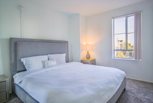 a white bedroom with a large bed and a window at Luxury 2 Bedroom 2 Bathroom Residence Green Park View in Los Angeles