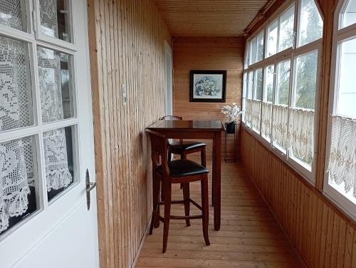 a small table and chair in a room with windows at Hochparterre mit Balkon und Gartenblick - Elisabeth von Berg in Rottweil