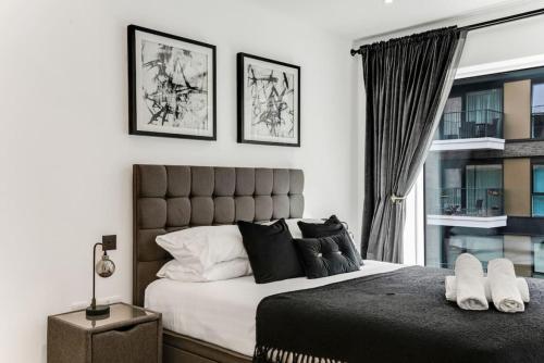 sypialnia z dużym łóżkiem i oknem w obiekcie Chic Chelsea 1BR Luxe Retreat, Serene Balcony w Londynie