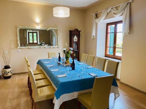 comedor con mesa azul y sillas en Villa Sissi, en Arliano