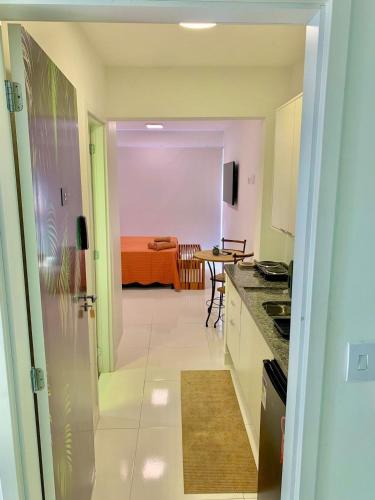 a kitchen and dining room with a table in the background at Studio Vertentes in Sao Paulo