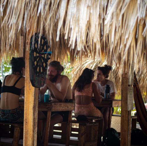 a group of people sitting at tables in a hut at Santa Lova Eco-hostel Isla Tintipan in Tintipan Island