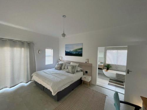 a bedroom with a bed and a bath tub in it at Coastal Cove in St Helena Bay