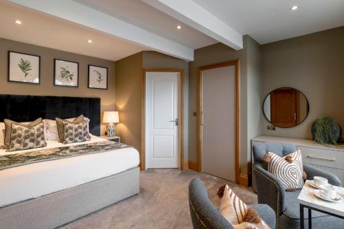 a bedroom with a bed and a table and chairs at Borrowdale Gates Hotel in Keswick