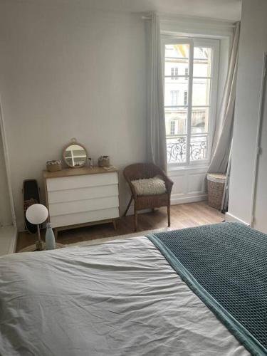 une chambre avec un lit, une commode et une fenêtre dans l'établissement Joli appartement centre-ville, à Caen