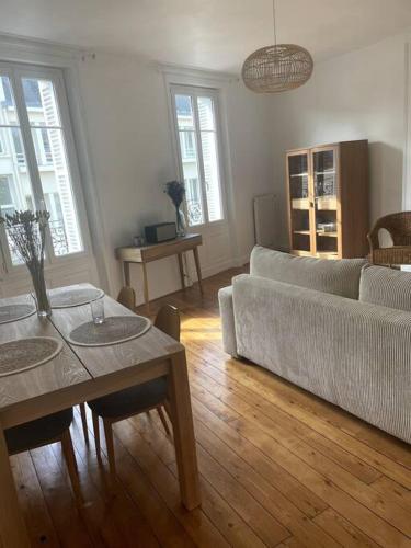 uma sala de estar com um sofá e uma mesa em Joli appartement centre-ville em Caen