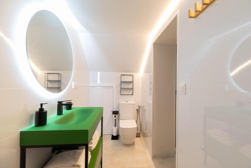 a bathroom with a green sink and a toilet at Loft Playa Samil in Vigo