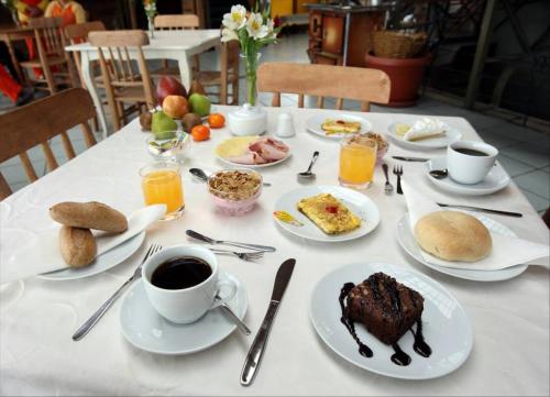 una mesa con platos de comida y tazas de café en Hotel Cabernet, en Valparaíso