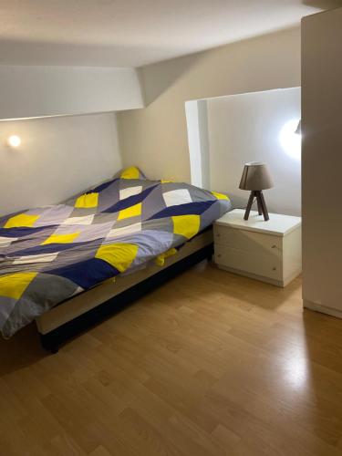 a bedroom with a bed and a lamp on a night stand at Mia’s duplex apartment in Skopje