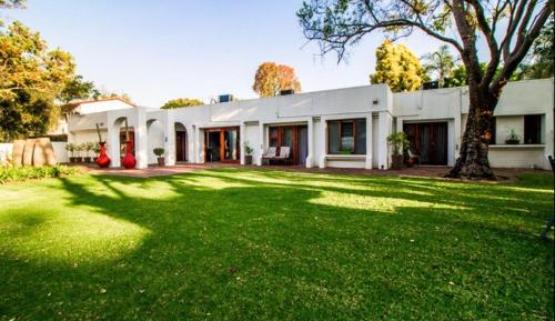 uma casa branca com um grande quintal em Richtershuyz Luxury Accommodation em Pretoria