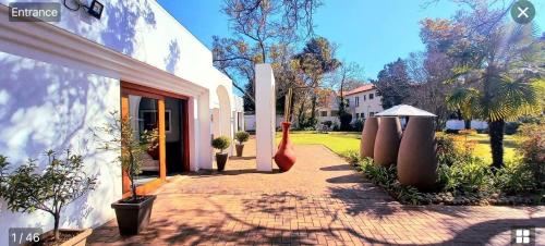 uma casa com um passadiço de tijolos ao lado de um edifício em Richtershuyz Luxury Accommodation em Pretoria