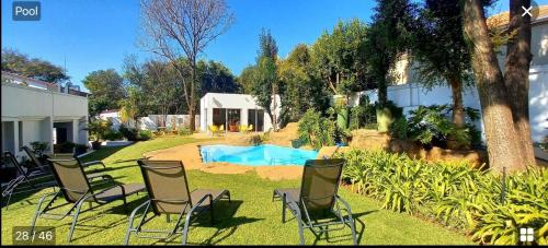 een groep stoelen in een tuin bij Richtershuyz Luxury Accommodation in Pretoria