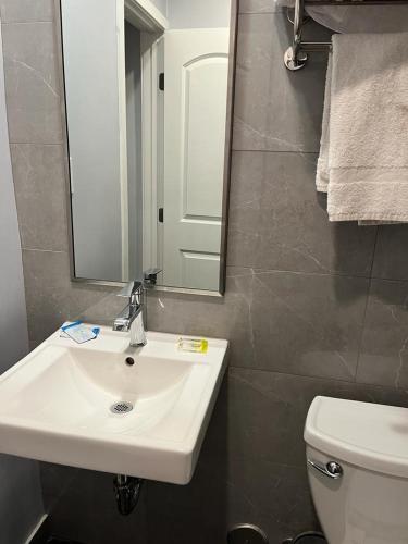 een badkamer met een wastafel, een spiegel en een toilet bij Budget inn Whittier in Whittier