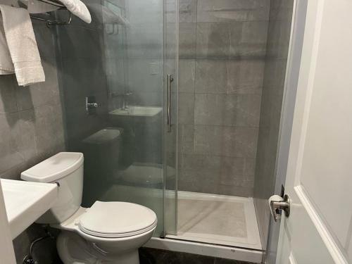 La salle de bains est pourvue de toilettes et d'une douche en verre. dans l'établissement Budget inn Whittier, à Whittier