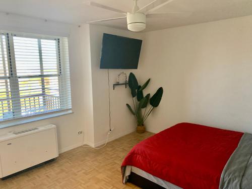 a bedroom with a red bed and a plant at New ATL Dwntwn Condo with Balcony 2 in Atlanta