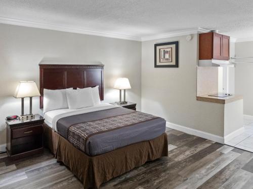 um quarto de hotel com uma cama e duas lâmpadas em Dream Inn em Fresno