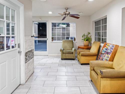 a living room with chairs and a ceiling fan at Dream Inn in Fresno