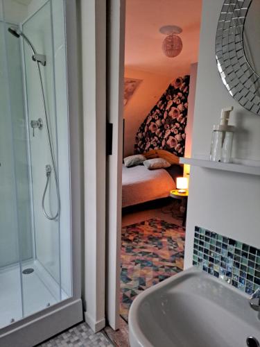a bathroom with a tub and a shower and a bedroom at Numéro 1 in Châteaulin
