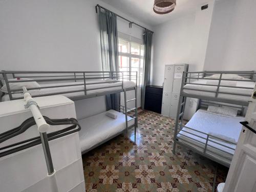 a room with three bunk beds and a window at BBTK Bed and Bike in Málaga