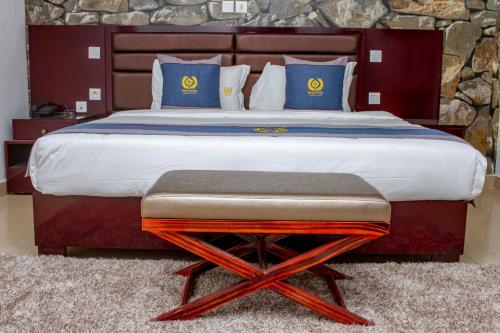 1 dormitorio con 1 cama grande con almohadas azules en SANA Hotel en Abiyán