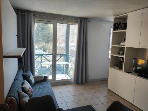 a living room with a couch and a large window at Chez Maxime Pre du Moulin in Briançon