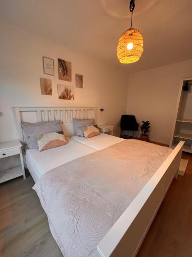 a large white bed in a bedroom with a lamp at Große Apartments für Monteure - Dorsten - in Dorsten
