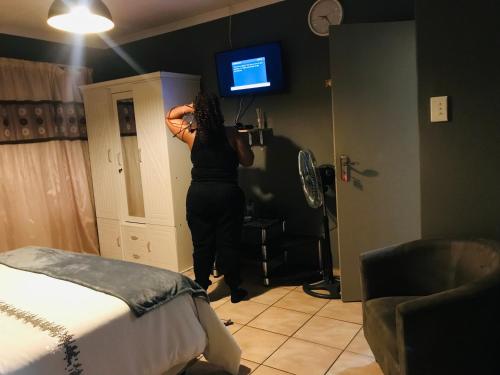 a woman standing in a room doing her hair at Ekhaya Sun Villa in Richards Bay