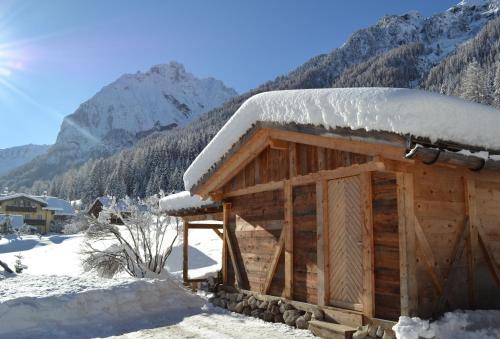 a log cabin with snow on top of it at Albergo Majorka in Canazei