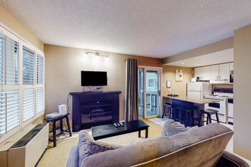 a living room with a couch and a table and a kitchen at Condo 503 at North Creek Resort in Blue Mountains