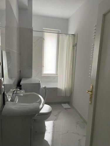 een witte badkamer met een toilet en een wastafel bij Simply Great in Toruń