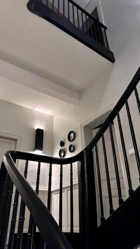 a spiral staircase in a house with a black railing at Maison d'Hôtes " L'INSTANT D'AILLEURS" in Albi