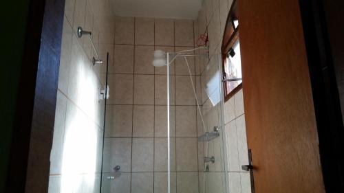 a bathroom with a shower with a glass door at Pousada Água do Mar in Trindade